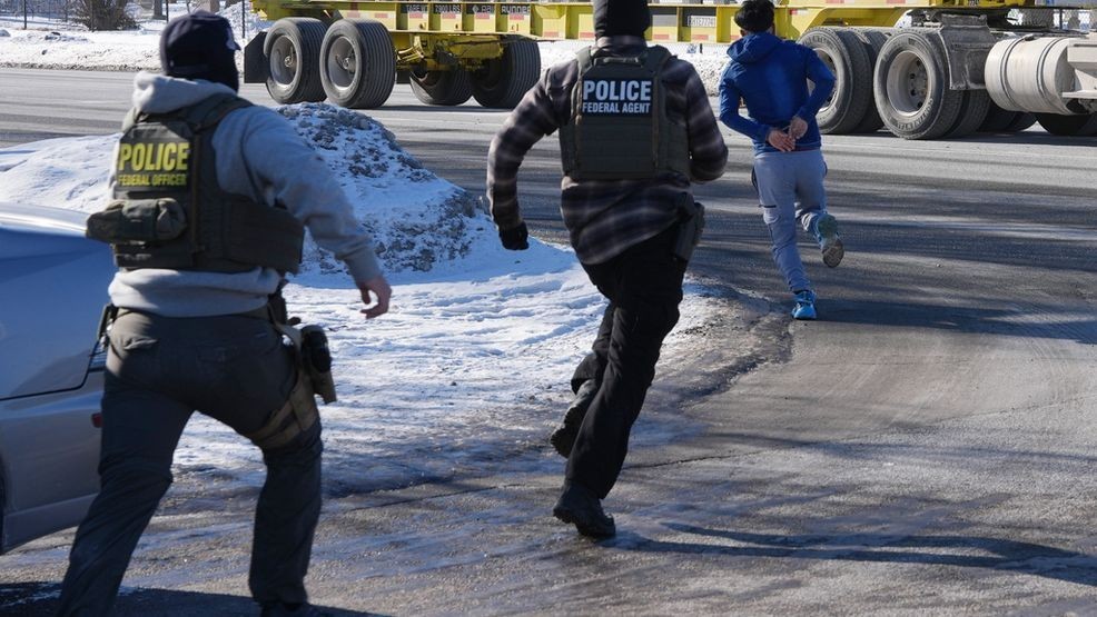 A man in handcuffs runs to avoid being detained by federal immigration agents on Tuesday, Jan. 27, 2026, in Minneapolis. (AP Photo/Adam Gray)