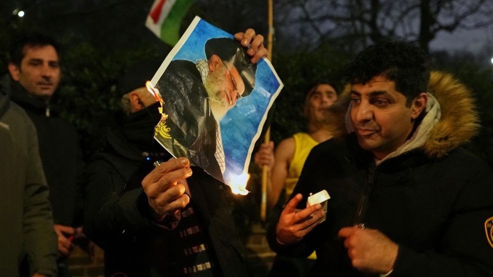 A picture of Ayatollah Ali Khamenei is set alight by protesters outside the Iranian Embassy in London, Monday, Jan. 12, 2026. (AP Photo/Alastair Grant)