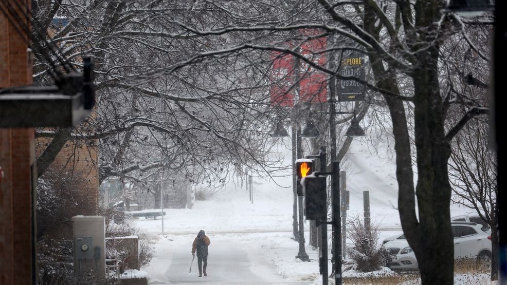 FILE - A pedestrian navigates a snow-covered sidewalk on Jan. 9, 2024 in Iowa City, Iowa. (Photo by Scott Olson/Getty Images)