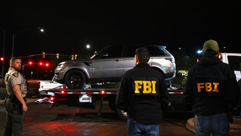 TUCSON, ARIZONA - FEBRUARY 13: FBI agents watch as a vehicle is towed from the parking lot of a restaurant on February 13, 2026 in Tucson, Arizona.  The Range Rover SUV was searched and its trunk sealed before it was removed.  The vehicle was located close to a neighborhood that law enforcement had sealed off earlier in the evening as the investigation into Nancy Guthrie's disappearance continues. (Photo by Brandon Bell/Getty Images)