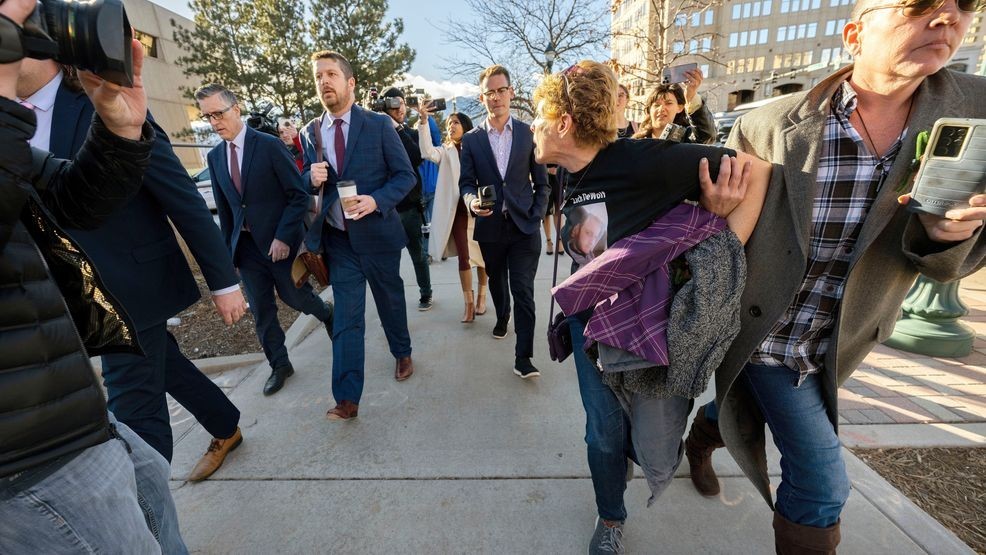 FILE - Chrystina Page, right, holds back Heather De Wolf, as she yells at Jon Hallford, left, the owner of Back to Nature Funeral Home, as he leaves with his lawyers following a preliminary hearing, Feb. 8, 2024, outside the El Paso County Judicial Building, in Colorado Springs, Colo. (Christian Murdock/The Gazette via AP, File)