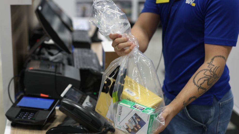Joshua Leyva, Best Buy sales advisor, packages up a customers purchase at Best Buy on December 23, 2025, in Miami. (Photo by Joe Raedle/Getty Images)