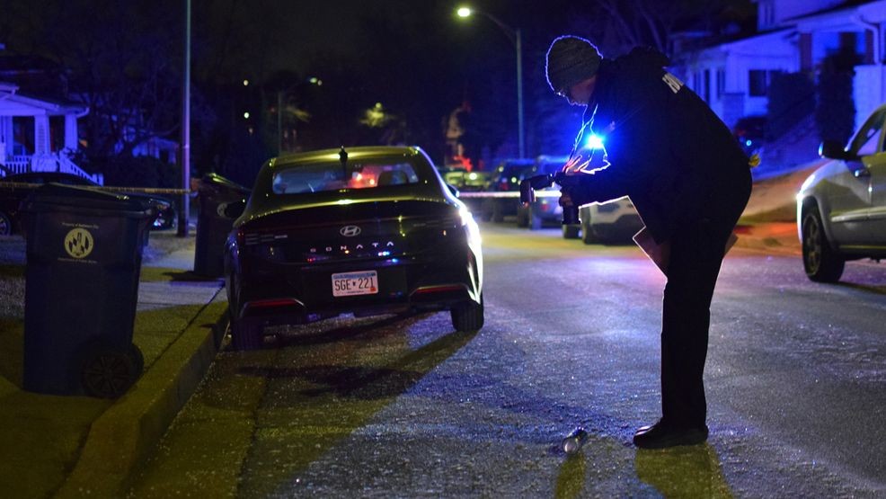 A crime lab technician takes pictures of a canister on the ground outside of a house in the 5400 block of Gerland Avenue following a shooting on Jan. 20. (WBFF / Maggie Ybarra){p}{/p}