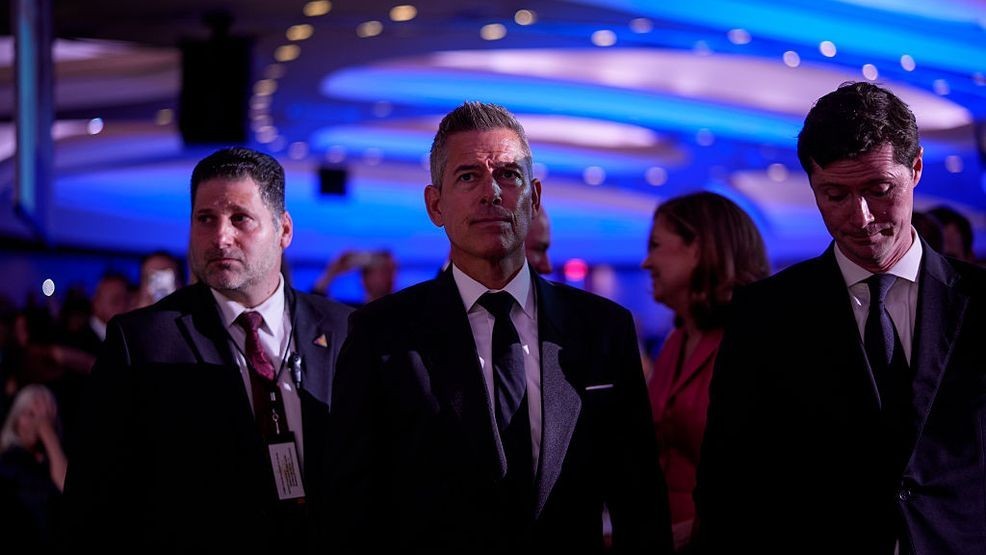 WASHINGTON, DC - APRIL 25: Transportation Secretary Sean Duffy (C) listens as White House Correspondents Association President and CBS Senior White House Correspondent Weijia Jiang comes back to the stage to speak after a shooting incident at the annual White House Correspondents Association Dinner April 25, 2026 in Washington, DC. According to reports, President Donald Trump, along with other government officials, were evacuated from the Washington Hilton after a shooting incident. (Photo by Andrew Harnik/Getty Images)