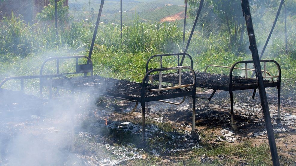 Charred hospital beds stand in smoldering Ebola treatment center in Rwampara, Congo, Thursday, May 21, 2026, after it was set fire by people angry at being stopped from retrieving a body, according to a witness and police. (AP Photo/Dirole Lotsima Dieudonne)