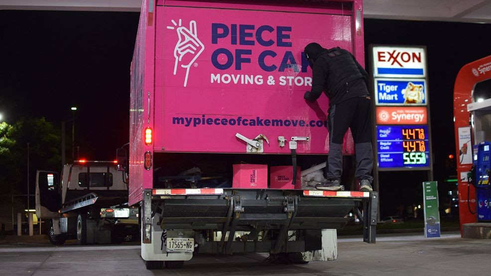 A tow truck driver prepares to remove a moving truck from New York from a gas station in southeast Baltimore. (WBFF / Maggie Ybarra)