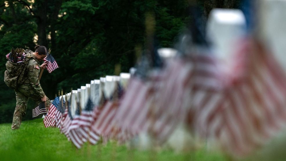 ARLINGTON, VIRGINIA - MAY 23: Members of the 3rd U.S. Infantry Regiment, also known as the "Old Guard," place flags at the headstones of U.S. military personnel buried at Arlington National Cemetery ahead of Memorial Day, on May 23, 2024 in Arlington, Virginia. Nearly 1,500 joint service members will spend around four hours placing small American flags in front of more than 260,000 headstones. The cemetery, consisting of 639 acres, is the final resting place of approximately 400,000 veterans and their dependents. (Photo by Kent Nishimura/Getty Images)