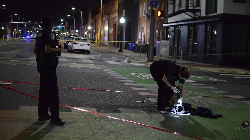 A crime lab technician collects evidence of gunfire at the intersection of Gough Street and South Central Street on Friday night. (WBFF / Maggie Ybarra)