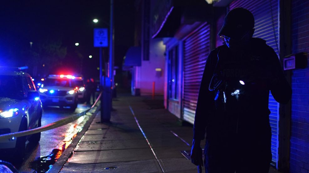 A crime lab technician searches for evidence of a shooting in the 1000 block of East Lombard Street on Thursday. (WBFF / Maggie Ybarra)DSC_0756.JPG