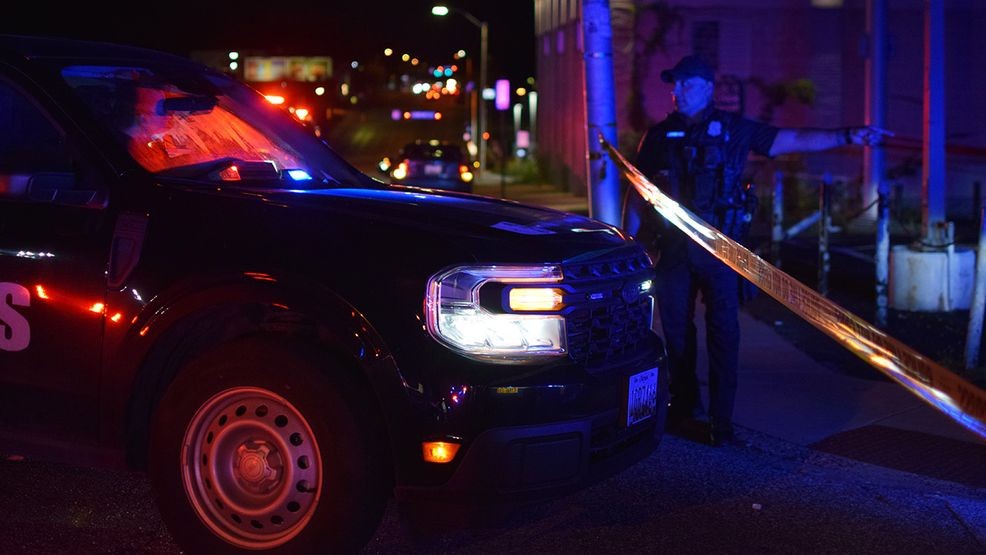 A Baltimore police officer talks to a crime lab technician about a shooting in the 4200 block of Arizona Avenue on Tuesday night. (WBFF / Maggie Ybarra)