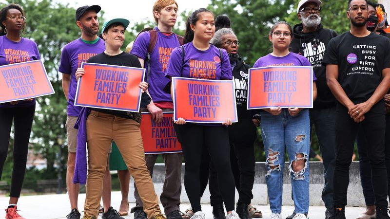 NEW YORK, NEW YORK - JUNE 11: People hold signs during a New York Working Families Party GOTV Rally for their endorsed candidates in Fort Greene Park on June 11, 2021 in the Fort Greene neighborhood of Brooklyn borough in New York City. Wiley held a series of campaign events on the eve of the start of early voting in NYC on the cusp of a rise in support according, to an Emerson College poll released on Wednesday, after major endorsements by Rep. Alexandria Ocasio-Cortez (D-NY), Public Advocate Jumaane D. Williams, who is running for re-election, and the Working Families Party.  (Photo by Michael M. Santiago/Getty Images)