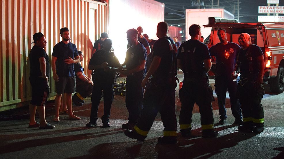 People with property in the area of a fire behind the Patapsco Market gather next to firefighters in hopes of learning more about the fire damage. (WBFF / Maggie Ybarra)