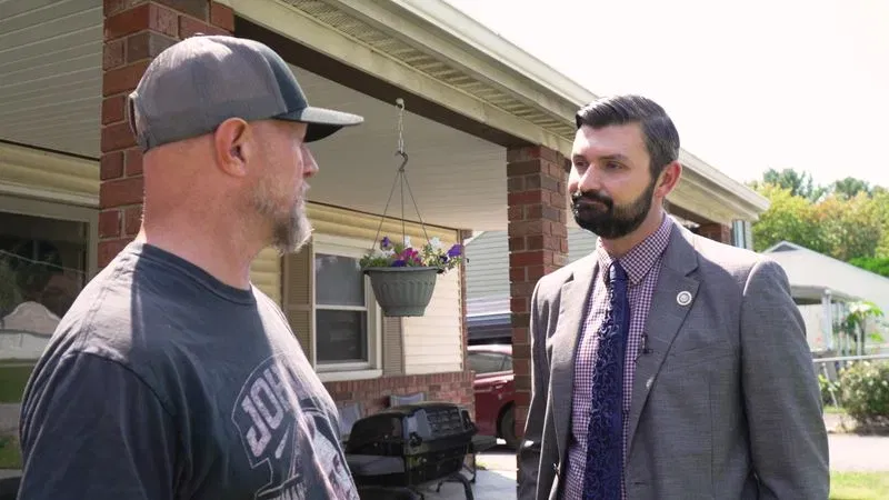 After Spotlight on Maryland's report on an alleged repeat squatter in Middle River, Md., Maryland Del. Ryan Nawrocki, R-Baltimore County, right, walked the neighborhood near his house, speaking with neighbor John Callick, left. (Steve Pierce/Spotlight on Maryland)