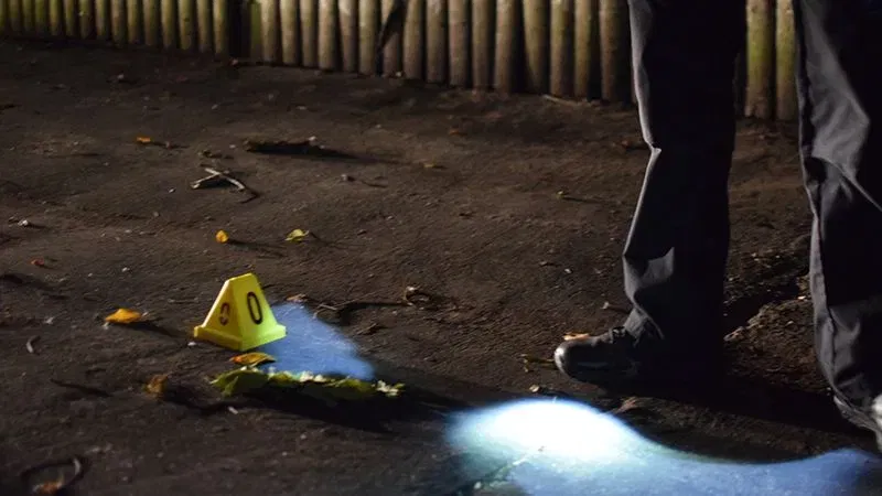 A crime lab technician stands next to a piece of evidence found near the spot where a person was killed on Friday morning. (WBFF / Maggie Ybarra)
