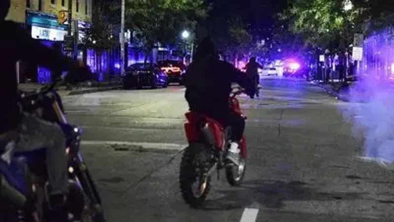 {p}Dirt bike riders perform tricks next to a crime scene in Federal Hill on Sunday morning. (WBFF / Maggie Ybarra){/p}