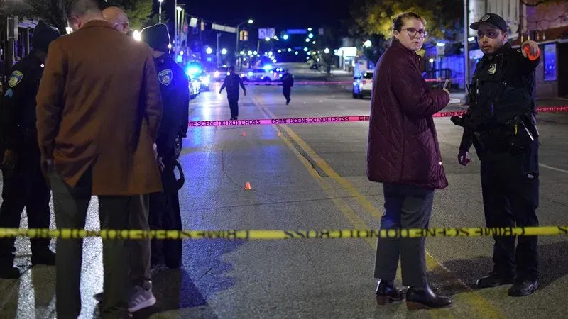 An officer directs the attention of homicide detective Kelsey Roberts toward a separate cluster of cartridge casings on Belair Road. (WBFF / Maggie Ybarra)