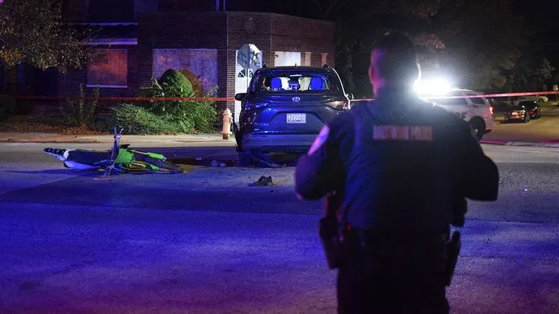 A Baltimore police officers guards the parameter of a crime scene on Harford Road following a crash that left a dirt bike rider with life-threatening injures on Wednesday night. (WBFF / Maggie Ybarra)