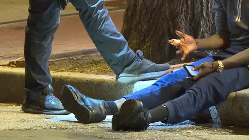 A man displays an injured hand after police detain him in the 600 block of S. Broadway on Tuesday night. (WBFF)