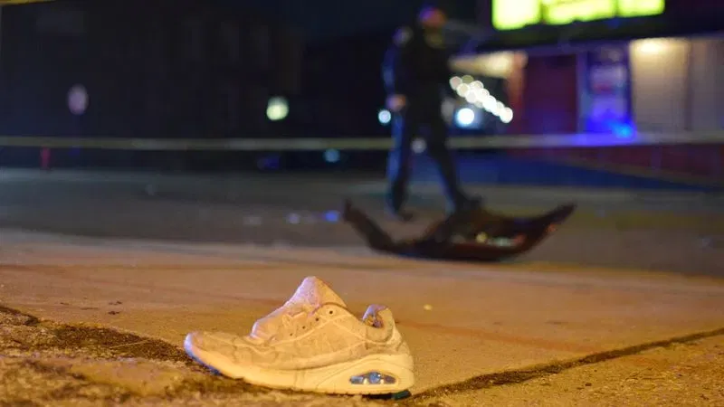 Investigators examine car parts strewn across the 2400 block of Orleans Street after a pedestrian was struck by a vehicle on Tuesday night. (WBFF / Maggie Ybarra)